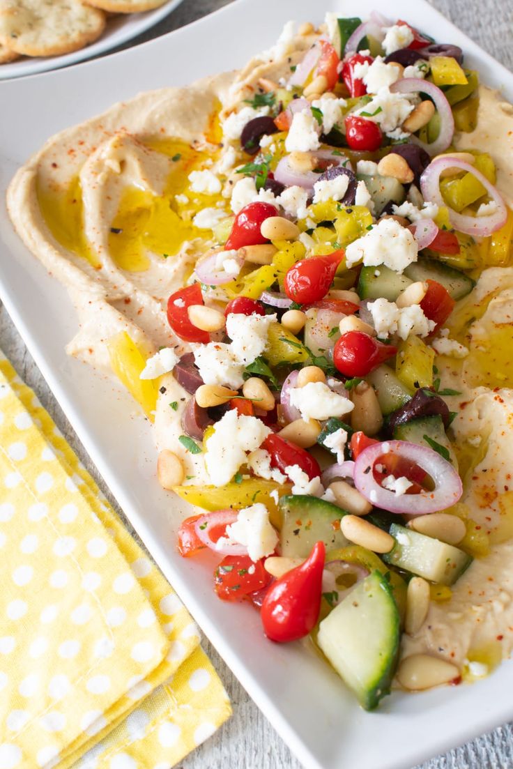 a white plate topped with vegetables and pita bread