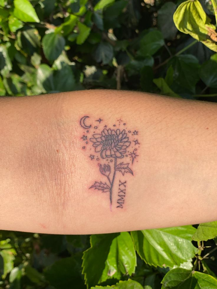 a woman's arm with a dandelion tattoo on it