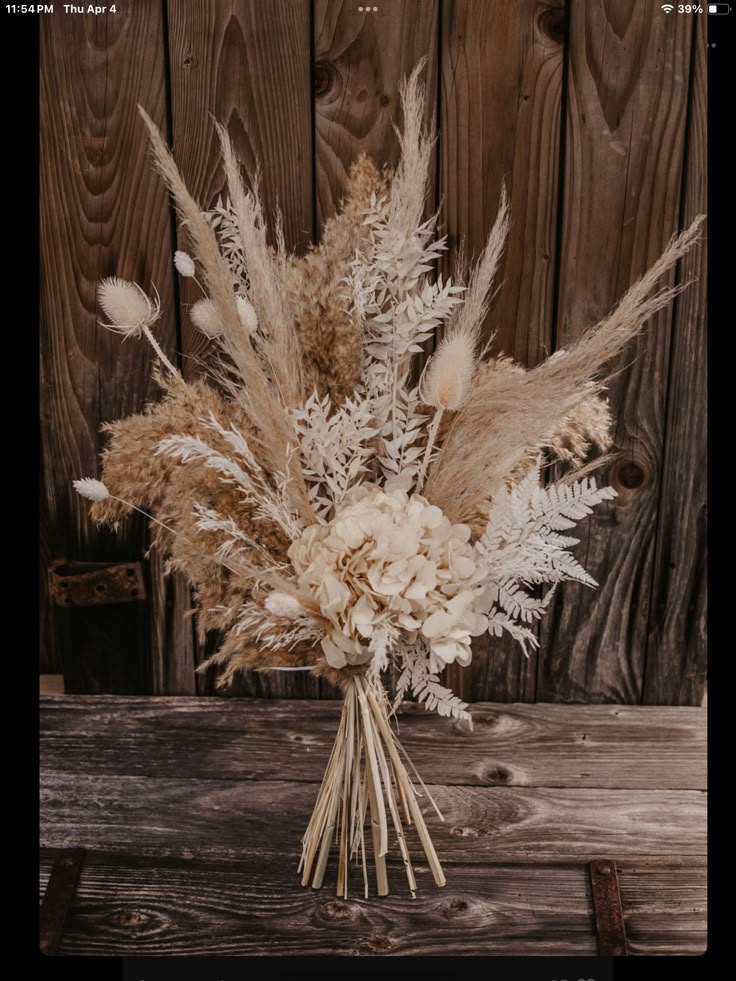 a bouquet of dried flowers sitting on top of a wooden table