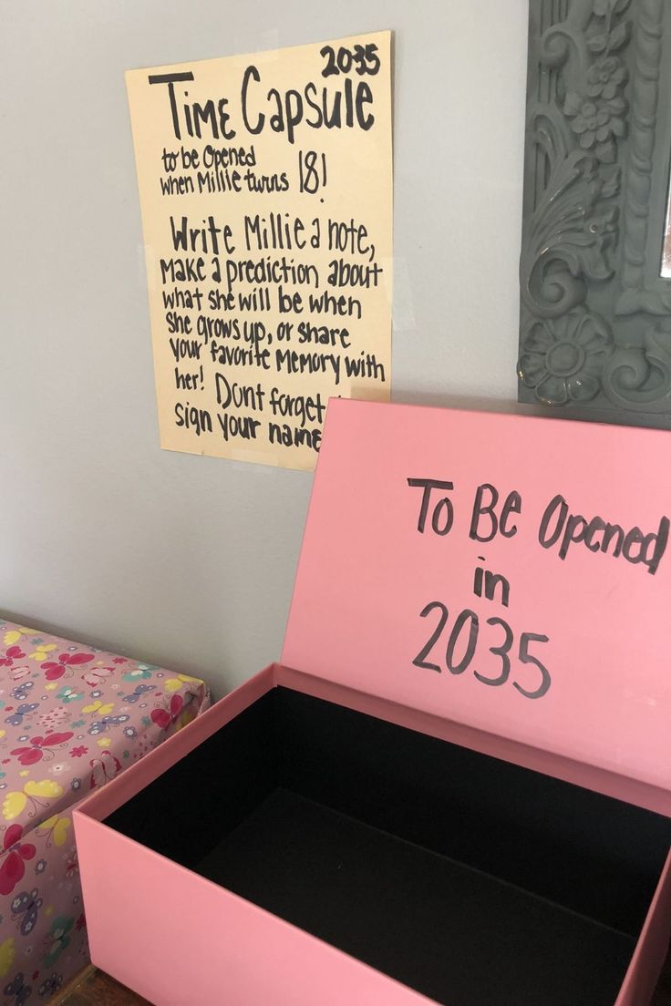 a pink box with the words to be opened in 2055 written on it next to a bed