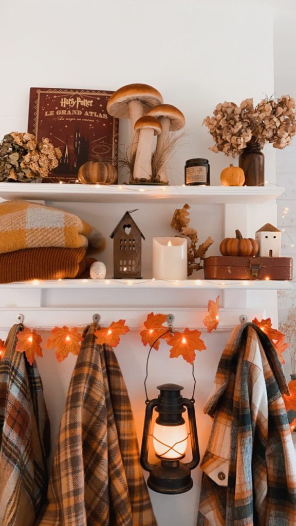 a shelf filled with fall decorations and blankets