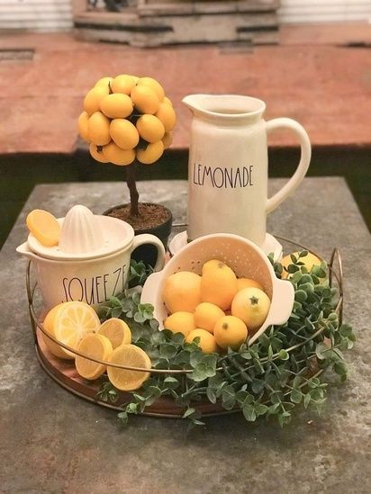 there are lemons in the bowl and two mugs with lemons on them