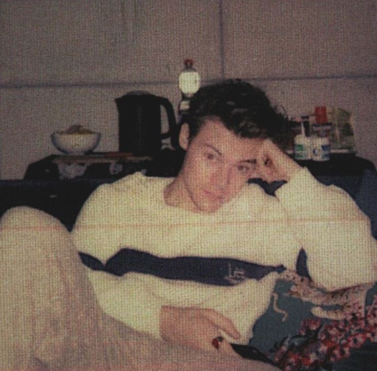 an old photo of a man sitting on a couch with his head in his hands