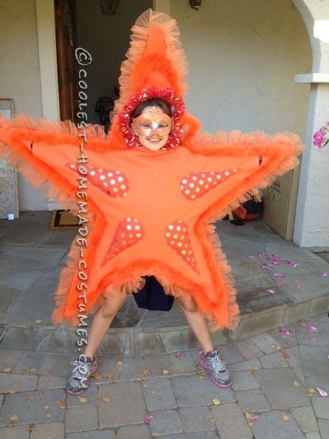 a woman in an orange star costume poses for the camera