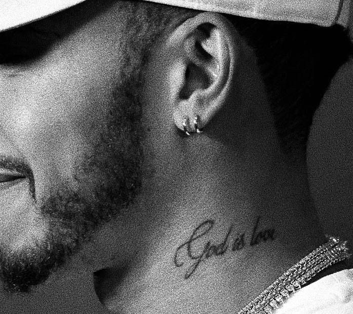 a close up of a person with a hat on his head and tattoos on his neck