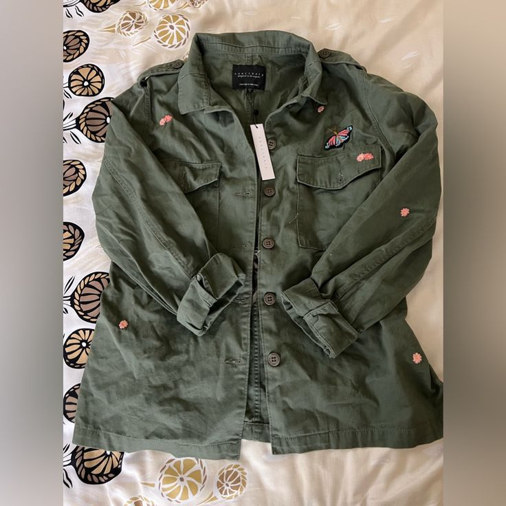 This Cute Light Weight Military Style Jacket From Sanctuary Is The Perfect Spring Jacket. With Beautiful Embroidered Flowers Throughout To Stand Out From Other Military Style Jackets. Button Front Closure. Size Large, But Does Fit Smaller And No Real Stretch Since It’s 100% Cotton. Can Tighten String Inside The Back Of Jacket To Give A Cinched In Waist Look. Black Military Jacket, Military Jacket Women, Faux Leather Vest, Green Utility Jacket, Shearling Vest, Spring Jacket, White Camo, Military Style Jackets, Anthropologie Jacket