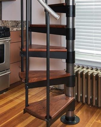 a spiral staircase in a kitchen next to an oven and stove with the door open