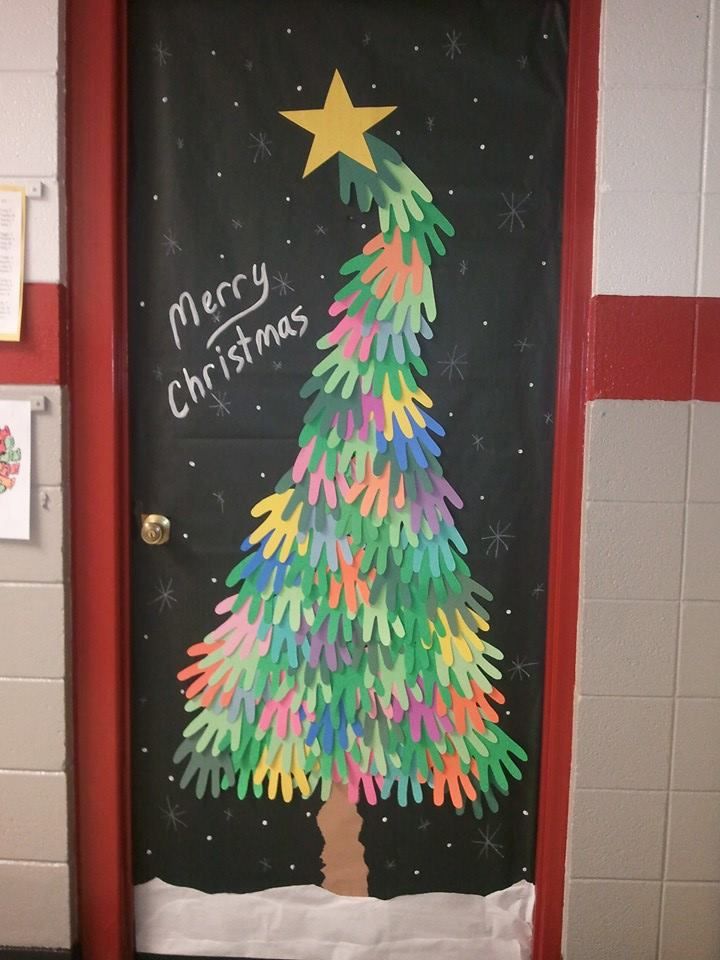 a christmas tree made out of crayons on a door with the words merry christmas written on it