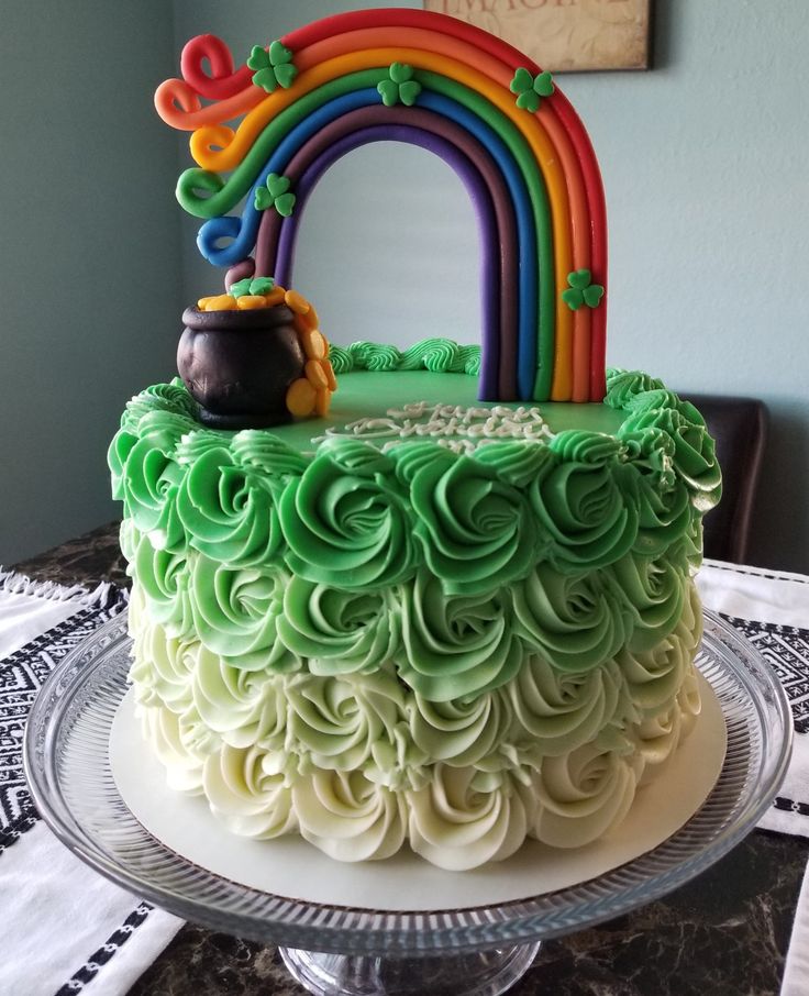 there is a cake with green frosting and a rainbow on top