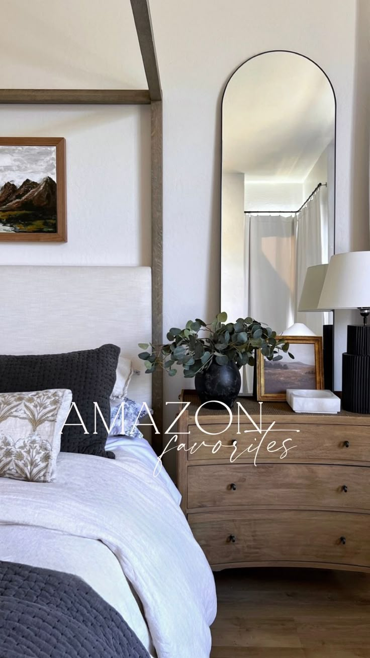 a bed sitting next to a dresser with a mirror on top of it in a bedroom