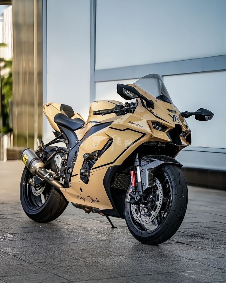 a gold motorcycle parked in front of a building