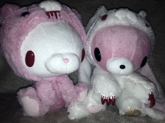 two hello kitty stuffed animals sitting next to each other