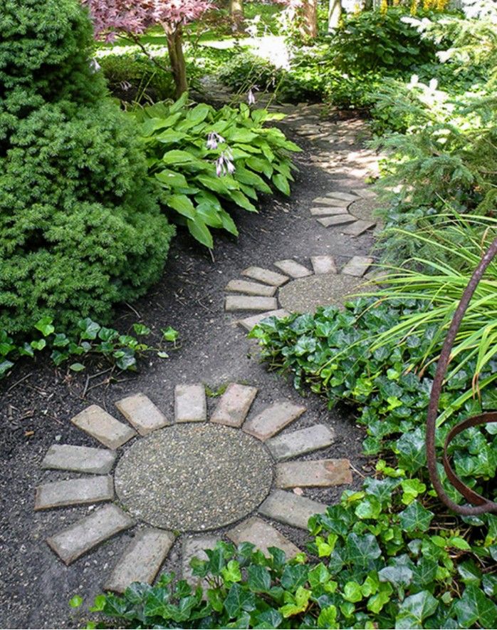 a stone path in the middle of a garden