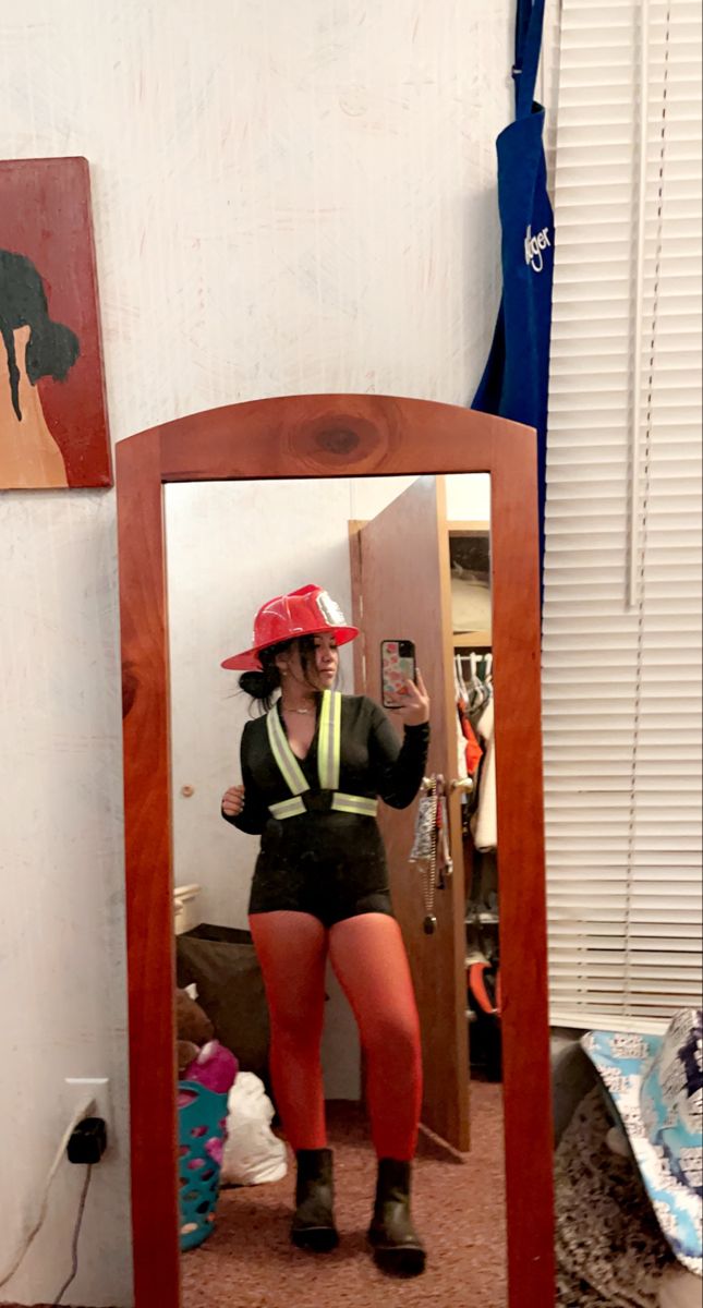 a woman is taking a selfie in front of a mirror with her hat on