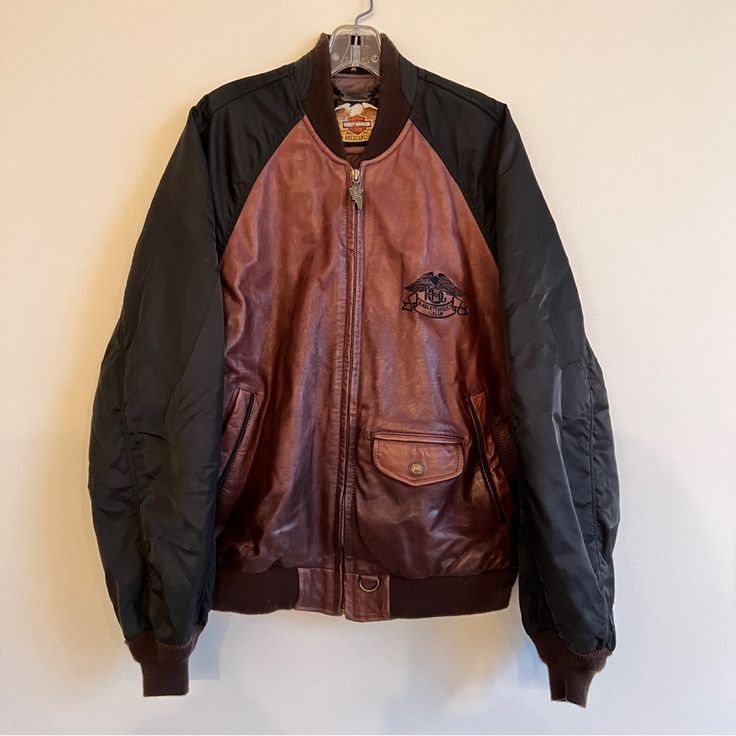 Fantastic Vintage Harley Davidson Jacket From The 1980s! Heavy Duty Brown Leather Motorcycle Bomber With Black Windbreaker Sleeves And Brown Ribbed Stretch-Knit Cuffs And Collar. The Details On This Coat Are Beautiful From The Logo Zipper Pull, To The Vintage Photo On The Interior Lining, To The Metal Hog Member’s Tag (Unused). The Leather Is High Quality, Soft And Supple, And The Weight And Warmth Of The Jacket Is Substantial Without Feeling Too Fussy Or Stuffy. Styling Is Gender Neutral And Ca Vintage Brown Outerwear For Winter Streetwear, Vintage Brown Fall Outerwear For Streetwear, Vintage Brown Fall Streetwear Outerwear, Retro Black Leather Jacket With Pockets, Vintage Brown Leather Jacket For Streetwear, 90s Brown Winter Outerwear, 90s Style Brown Long Sleeve Outerwear, 90s Brown Long Sleeve Outerwear, Harley Davidson Jacket