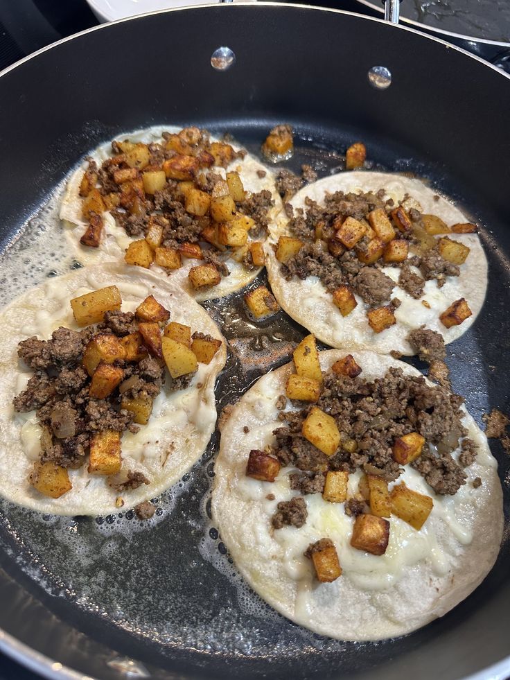 three tortillas are being cooked in a skillet