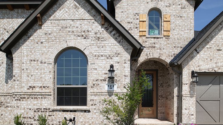 a brick house with two garage doors and windows