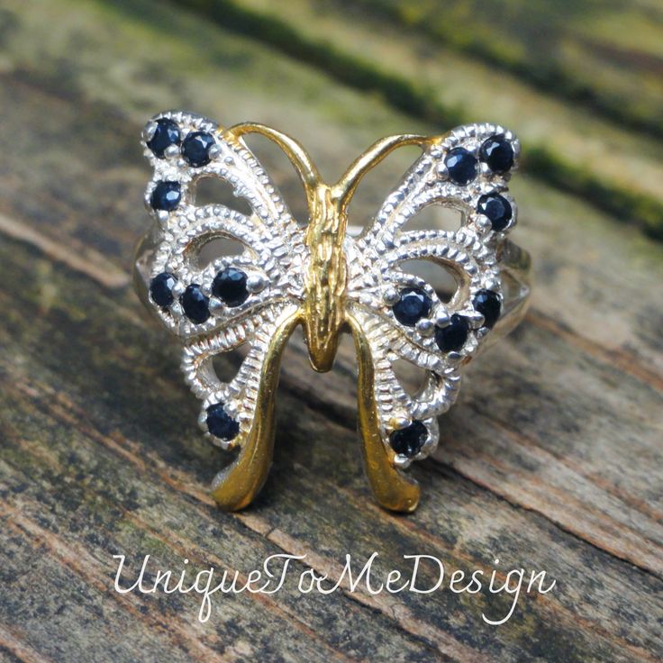 Handmade, Natural Blue Sapphire Butterfly Sterling Silver, 14k Yellow Gold Ring Size 7.5 🦋Featured in this listing is a sterling silver, handmade, natural stone ring.  This lovely handmade ring features a beautiful, Natural Blue Sapphire  stones that have been set within a large butterfly. Each round faceted Blue Sapphire gemstones has been prong set into highly polished Sterling Silver with 14k gold accents throughout highly detailed ring.  🦋Made with 100% Natural gemstones, with a statement Gold Sterling Silver Butterfly Ring For Anniversary, Blue Sterling Silver Jewelry Stamped 14k, Unique Gold Sapphire Ring In Sterling Silver, Fine Jewelry Sterling Silver Butterfly Ring Gift, Elegant Blue Sterling Silver Butterfly Ring, Silver Sapphire Ring For Jewelry Making, Sterling Silver Sapphire Ring Stamped 925 As Gift, Silver Butterfly Ring With Gemstone Fine Jewelry, Silver Butterfly Ring With Gemstone In Fine Jewelry Style