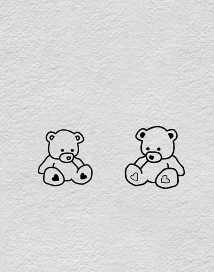 two teddy bears sitting next to each other on a white paper background with black ink