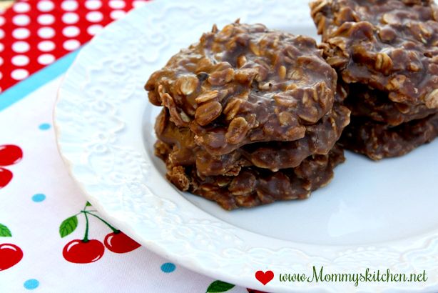 two chocolate cookies on a plate with cherries