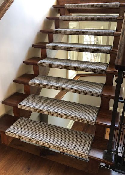 a set of stairs with carpeted treads and wooden handrails in a home