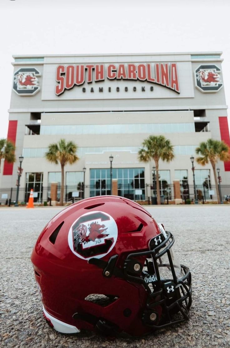 a football helmet sitting on the ground in front of a building that says south carolina