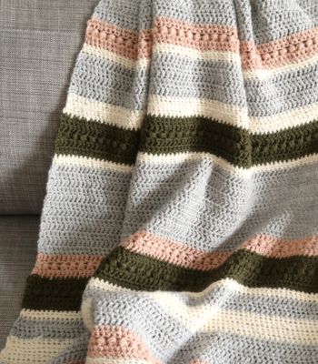 a crocheted blanket sitting on top of a couch