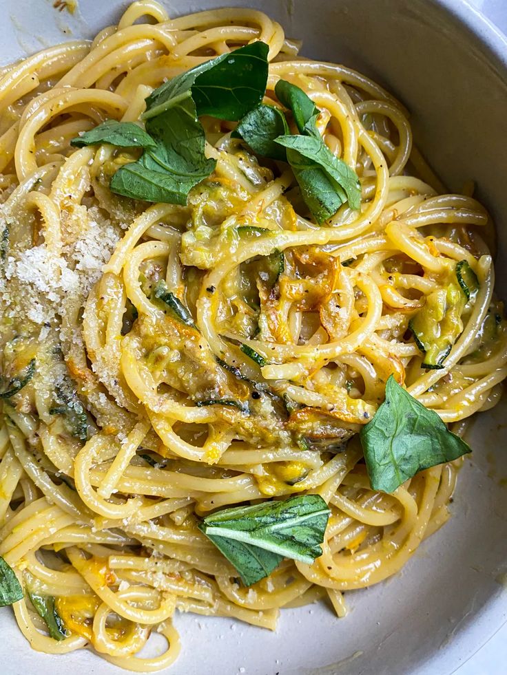 a white bowl filled with pasta and pesto