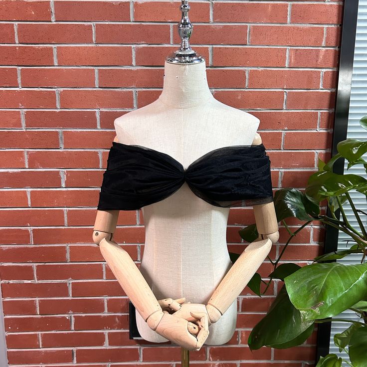 a mannequin wearing a black and white top with bow tie around the bust