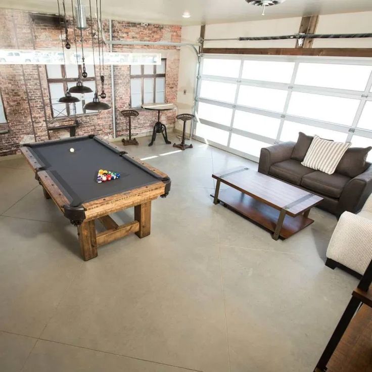 a living room with a pool table and couches