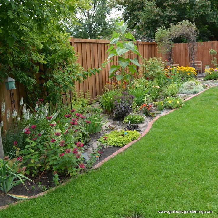 a garden with lots of different types of flowers and plants in the middle of it