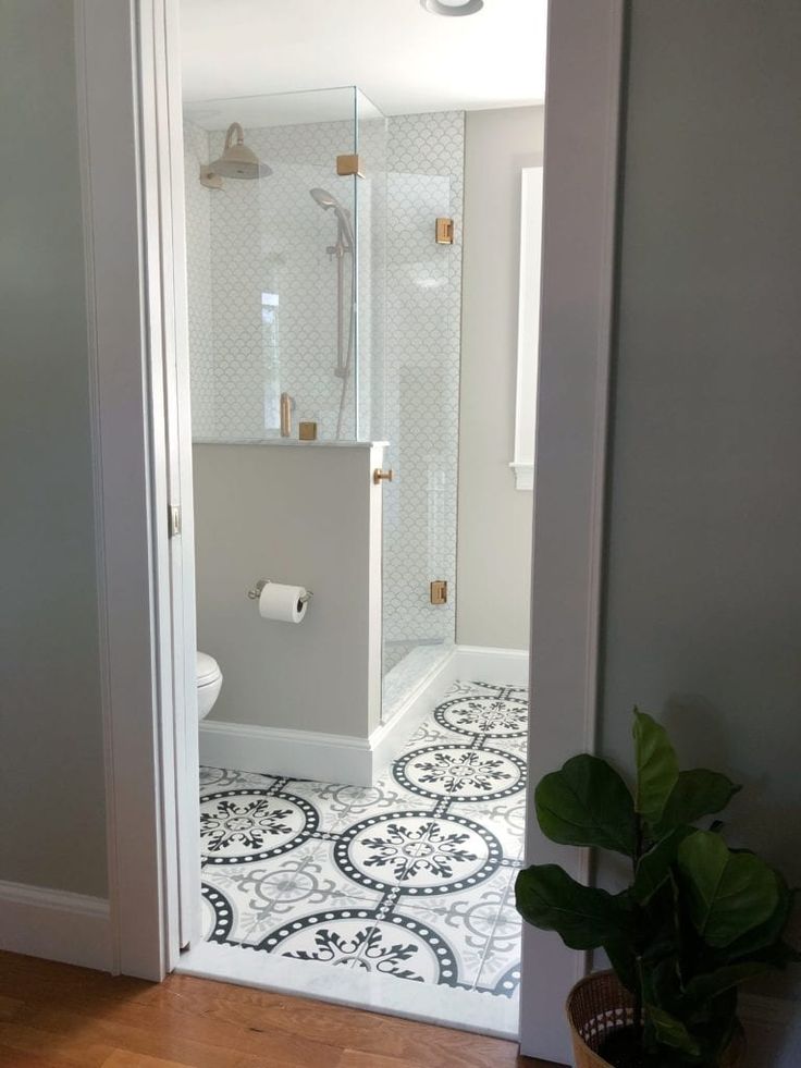 an open door leading to a bathroom with a toilet and shower stall in the corner