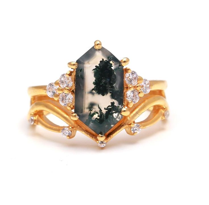 a gold ring with an oval shaped green and white stone