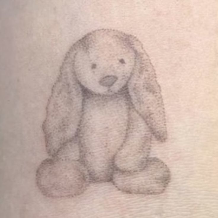 a drawing of a stuffed animal on the back of a person's arm,