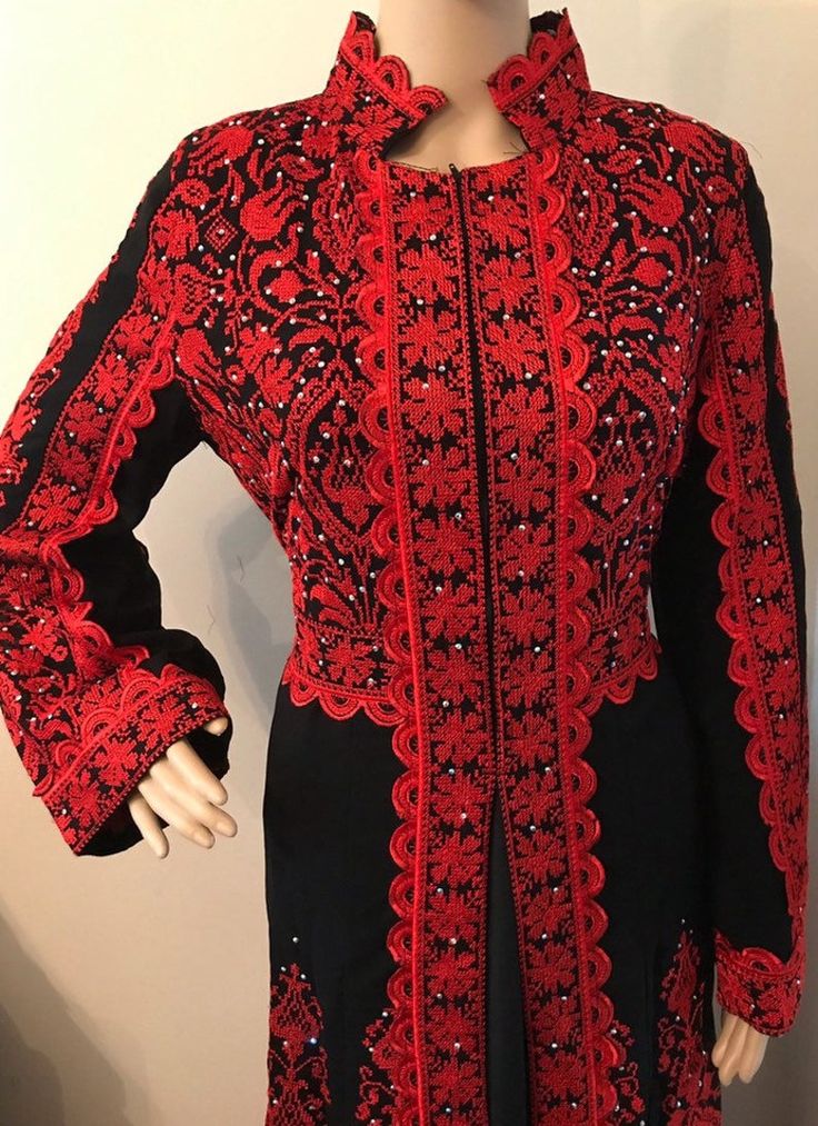 a mannequin wearing a red and black dress with an elaborate pattern on it