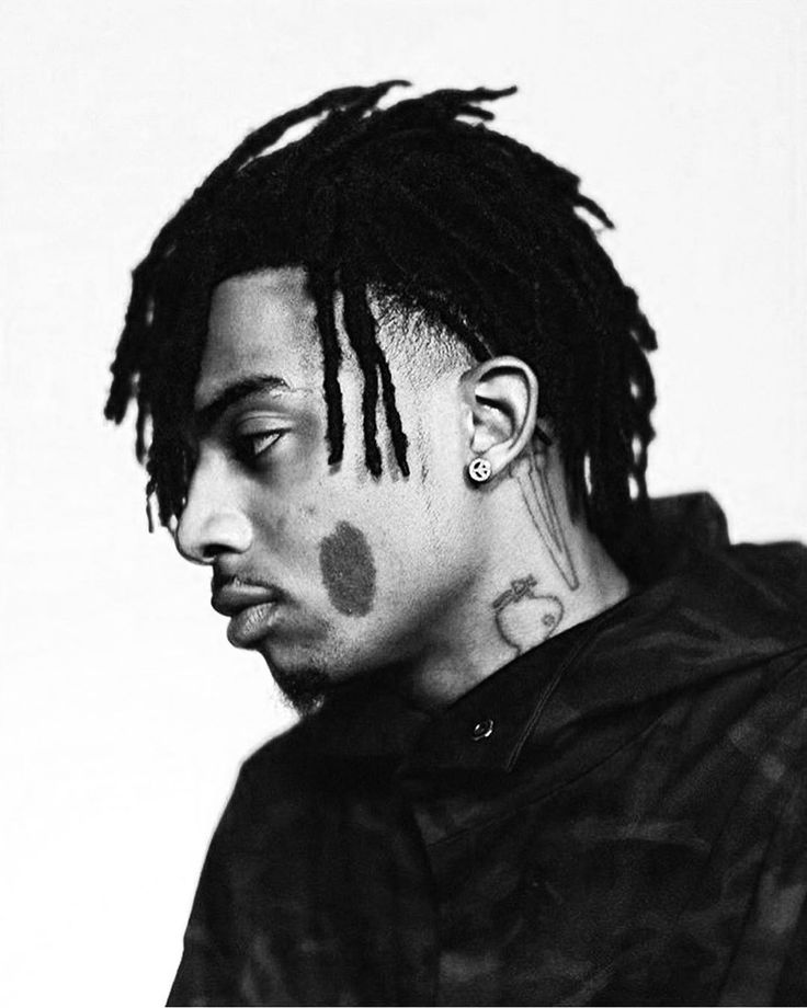 a black and white photo of a young man with dreadlocks on his head