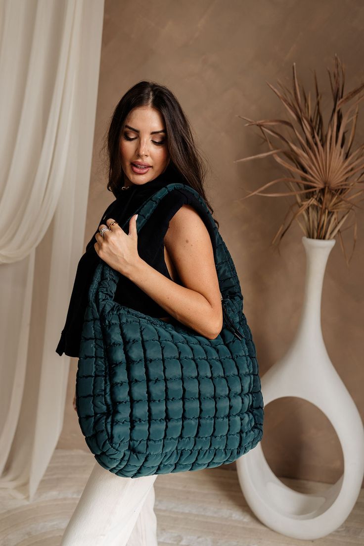 The Olivia Quilted Tote is both functional and stylish, available in forest green, sand grey, black, or tan. Measuring 20" x 7" x 15", this spacious tote features a secure zipper closure and a 27" long strap for comfortable carrying. The water-resistant inner lining helps protect your belongings, while two interior pockets keep your essentials organized. Additionally, two exterior side pockets offer convenient access to frequently used items. Perfect for daily use or weekend getaways, the Olivia Green Travel Bags For Winter, Versatile Green Bags For Fall, Modern Green Bag For Fall, Large Capacity Green Bag For Fall, Modern Green Bags For Fall, Green Bag With Removable Pouch For Fall, Versatile Green Bag For Fall, Winter Travel Hobo Shoulder Bag, Green Shoulder Bag For Fall