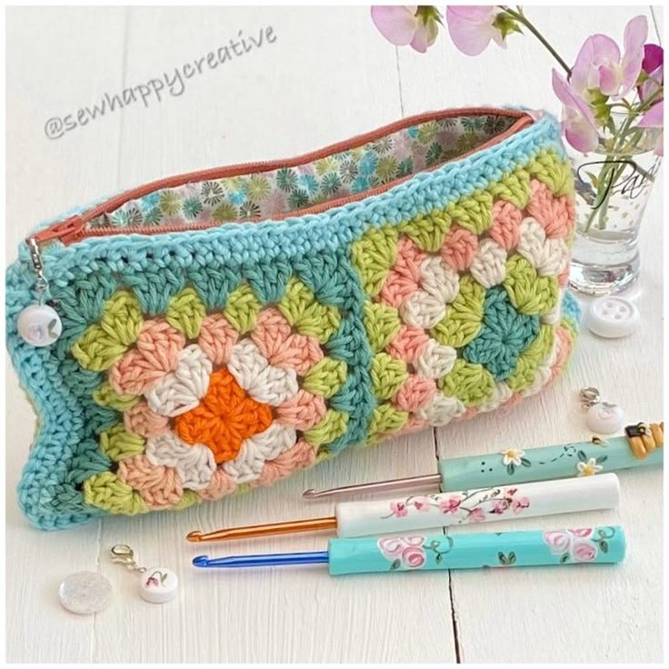 a crocheted purse sitting on top of a white table next to a pen