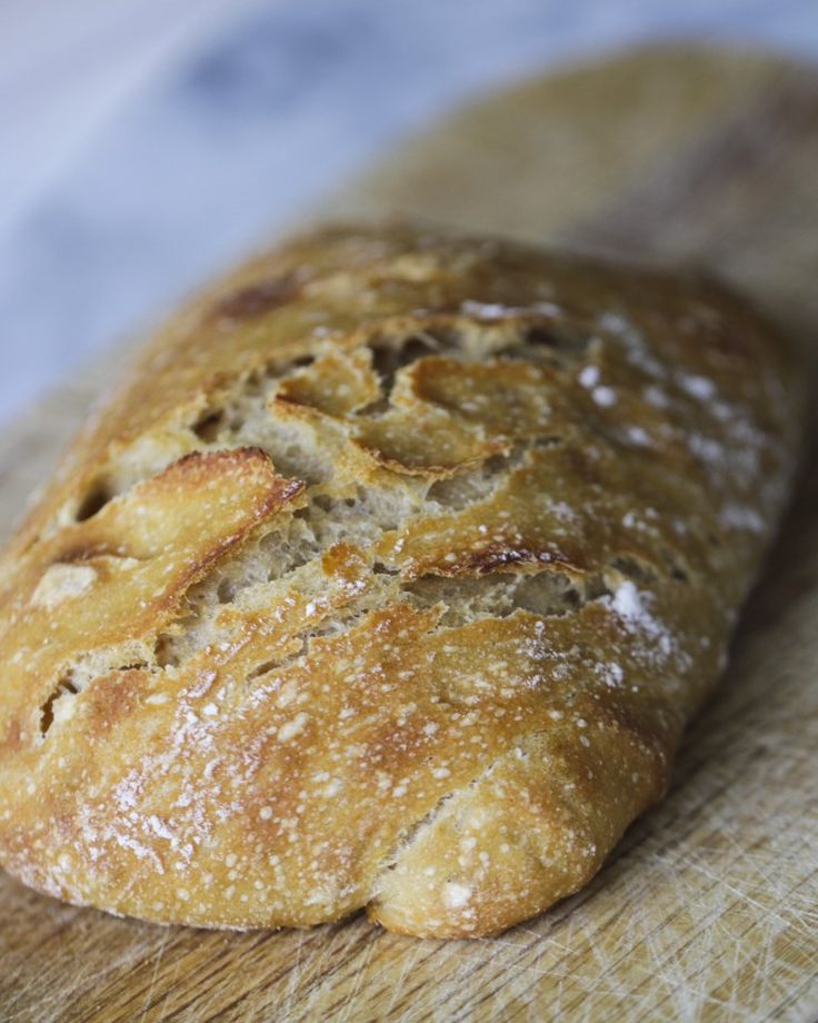 a loaf of bread sitting on top of a wooden cutting board