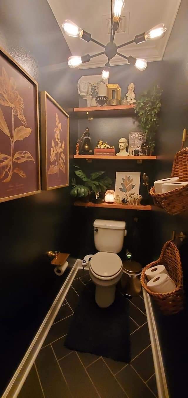 a toilet in a bathroom with pictures on the wall and shelves above it, along with other items