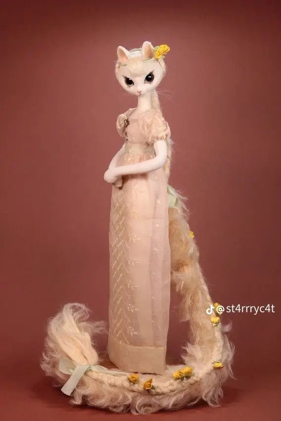 a stuffed animal is dressed in a long dress with feathers on it's tail