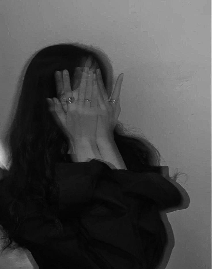 a woman covering her face with both hands