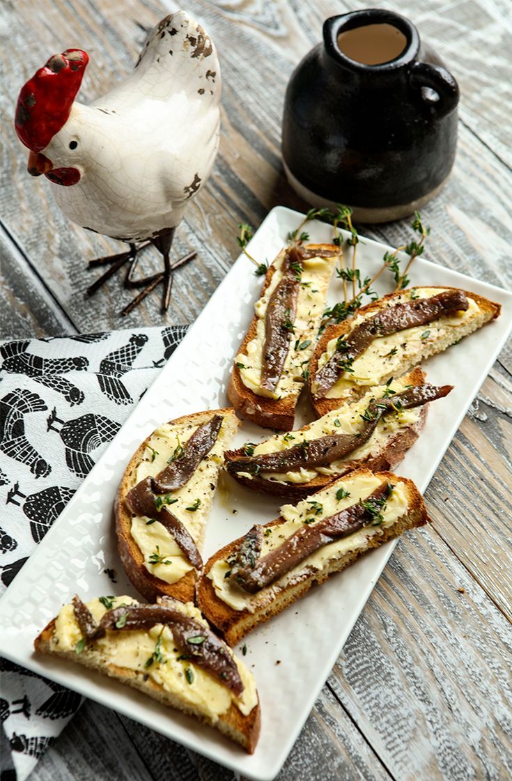 bread with cheese and herbs on a plate next to a bird