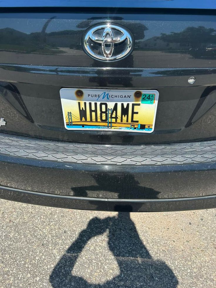 the back end of a black toyota car with license plate that reads wh8me