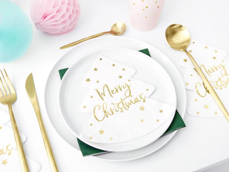 a white plate topped with a christmas tree next to gold utensils and napkins