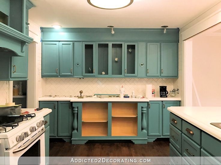 a kitchen with blue cabinets and white counter tops is shown in this image from the front view