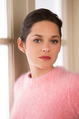 a woman in a pink sweater looking at the camera