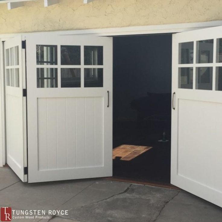 an open garage door on the side of a house that has windows and doors in it