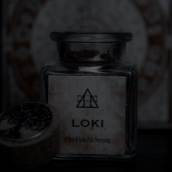 an empty glass jar sitting on top of a table next to a wooden container with the word loki written in it