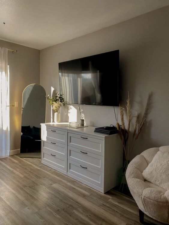 a living room with white furniture and a flat screen tv